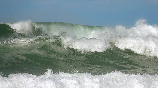 ocean sea green waves splashing. foam. Blue sky