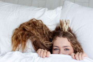 Woman sleeping. High angle view of beautiful young woman lying in bed covered with blanket. Young...