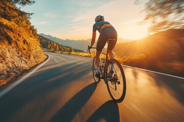 Cyclist enjoying a fast ride on a winding mountain road during golden hour