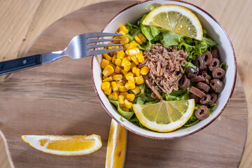 Fresh Tuna Salad Bowl with Corn, Olives, Lettuce, and Lemon Slices – Healthy Lunch, Mediterranean Cuisine, Clean Eating Concept, Overhead View