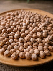 Raw Chickpeas on a rustic wooden table. Dry chickpea background close up. Chickpea legumes seed background.