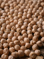 Raw Chickpeas on a rustic wooden table. Dry chickpea background close up. Chickpea legumes seed background.