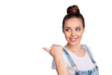 Portrait of charming lady showing at copy space by her forefinger looking wearing white t-shirt denim jeans overalls isolated over blue background