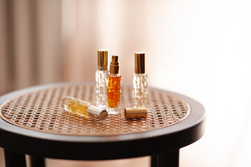 Glass bottle of fragrant perfumed water on rattan table in room. Aromatherapy.