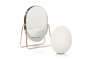 Whole egg reflecting in mirror as cracked, white background. Opposite, contrast, difference