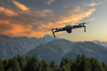 Drone with camera flying in mountains. Unmanned aerial vehicle for surveillance
