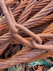Vertical nautical image of rusted chain and rope with nylon cord