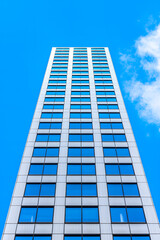 Fototapeta premium A low-angle view of a modern skyscraper with a blue sky