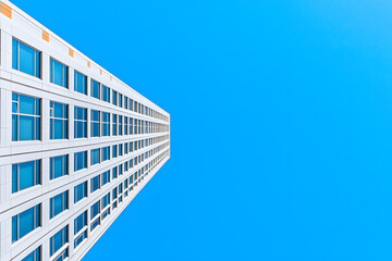 A low-angle view of a modern skyscraper with a blue sky