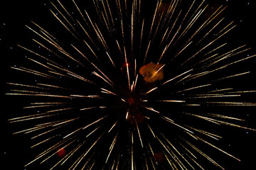 Spectacular golden fireworks show in night sky, shining sparks and trails perfect for celebration and backgrounds