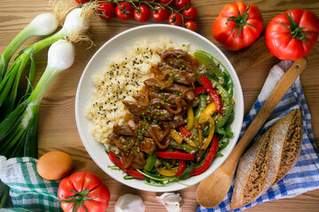 Dish with soy beef, peppers, and rice. Top view table.