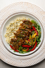Dish with soy beef, peppers, and rice. Top view table.