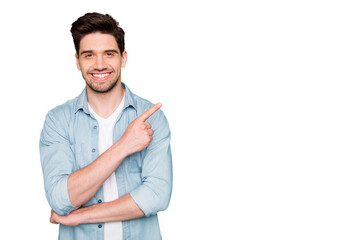 Photo of positive cheerful attractive handsome man pointing at empty space with forefinger smiling...