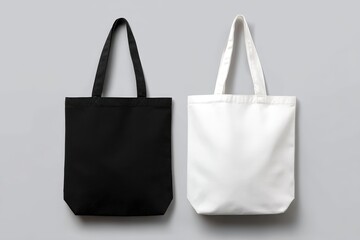 Two plain tote bags, one black and one white, are displayed side by side on a neutral gray background.