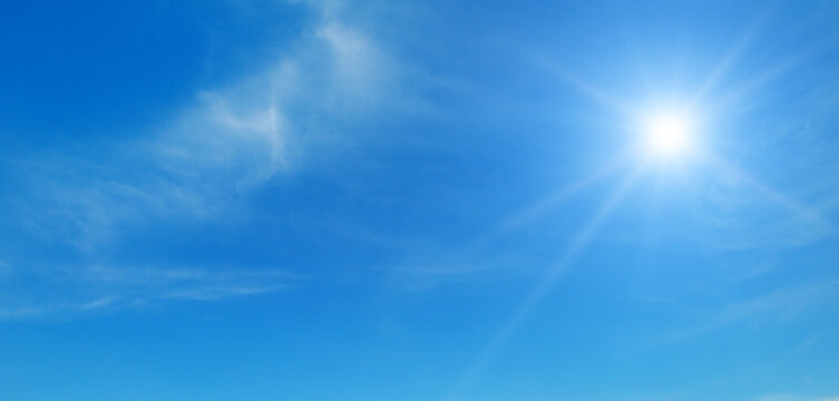 Blue sky with white clouds and bright sun.