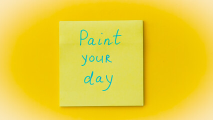 Inspirational phrase on a colorful sticky note, reminding to color your day bright.