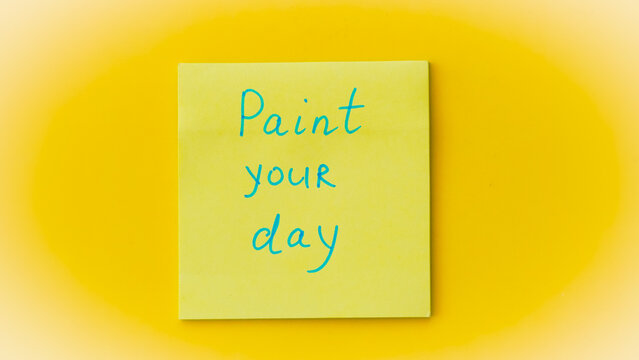 Inspirational phrase on a colorful sticky note, reminding to color your day bright.