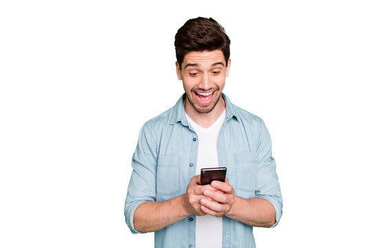 Photo of amazing guy holding telephone read new cool instagram post comments overjoyed positive reviews wear denim shirt isolated green color background