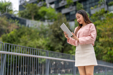 Fototapeta premium Portrait of smiling happy woman relax using digital tablet.Young asian girl working or study,chatting social network and playing game online or social media,shopping online