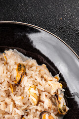 Rice seafood risotto mussels, shrimp, prawn, rapan, squid vegetable dish fresh gourmet food background on the table rustic food top view copy space