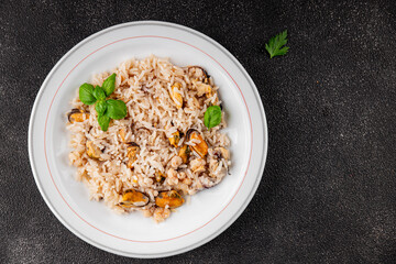 Rice seafood risotto mussels, shrimp, prawn, rapan, squid vegetable dish fresh gourmet food background on the table rustic food top view copy space