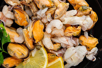Seafood mix frut de mer mussels, shrimp, prawn, rapan, squid dish fresh gourmet food background on the table rustic food top view copy space keto  paleo diet vegetarian pescetarian diet