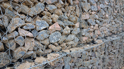 Gabion retaining wall filled with natural stones for landscape reinforcement