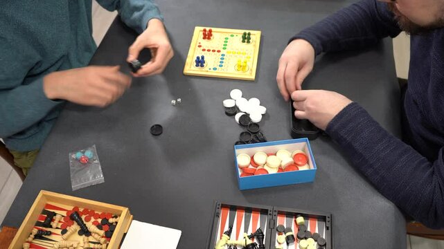 Board Games top view on table. Hands fold checkers. Play time