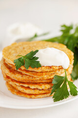 Potatoes pancakes latkes, flapjacks, hash brown or potato vada with parsley and sour cream  on table.