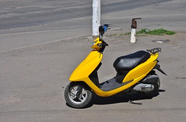 yellow moped on the street on a sunny day