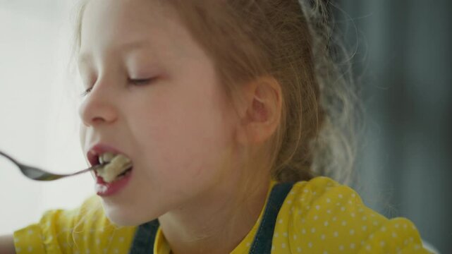 close up of white girl eating egg with fork, focused expression on face, messy bite captured, bright backlit window scene, casual home dining moment, close detail on lips and utensil motion