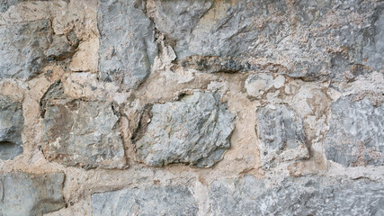 Rough stone wall background close-up. Textured debris stone wall background.