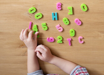 child learns numbers. close-up of children's hands holding numbers. home preschool education