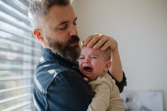Father comforting his crying baby son.