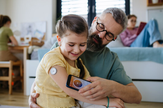 Diabetic girl with a CGM sensor on her arm.