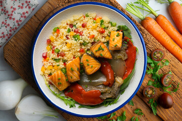 Dish with baked salmon, peppers and couscous salad. Top view table.