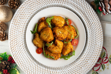 Cod fritters, a traditional Spanish tapa. Top view table with christmas decoration.