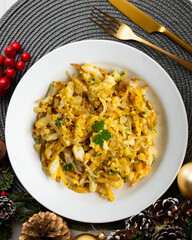 Cod o bras, golden cod with potatoes, a traditional Portuguese dish. Top view table with christmas decorations.