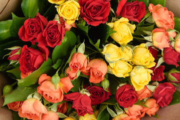 Full frame of beautifully decorated bouquet of red, yellow and orange roses.