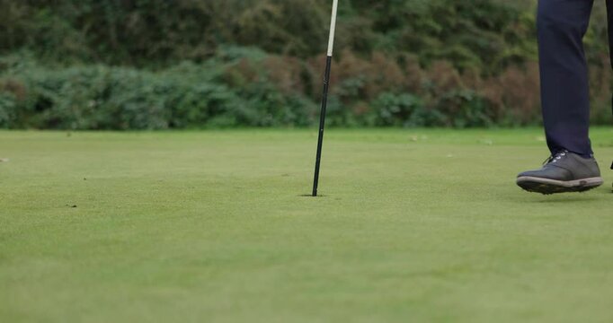 Closeup, person and legs with golf ball for tee on grass. lawn or course for practice. Athlete, professional or golfer for equipment for training of shot in competition, match or tournament in summer