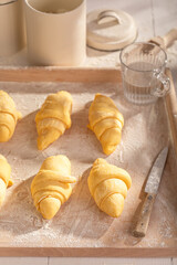 Delicious french croissants preparing from raw dough.