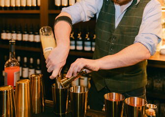 Bartender preparing cocktails at upscale bar in evening ambiance, showcasing mixology skills and elegant tools used