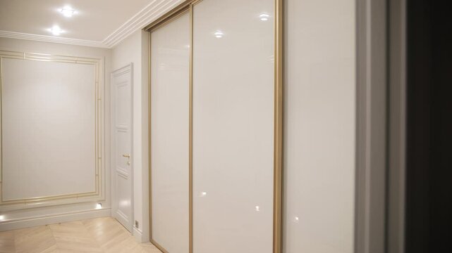Bright hallway with white sliding wardrobe and ceiling lights