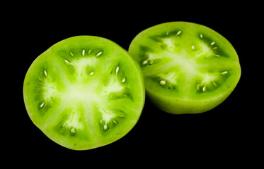Green tomato isolated on black background.