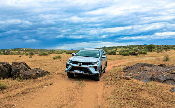 Off-road driving a rental car on a gravel road, a 4x4 track in a sandy desert landscape in Namibia. Toyota Fortuner SUV 4x4 off-road vehicle.
March 8, 2025.  Kalahari, Namibia Africa.