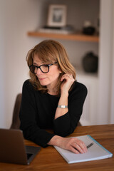 Blond haired proffessional female using laptop at home