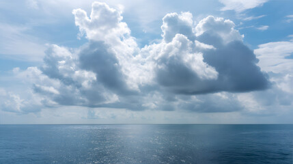 Fototapeta premium Bright morning on a calm ocean with fluffy clouds reflecting on the water surface in a serene coastal setting