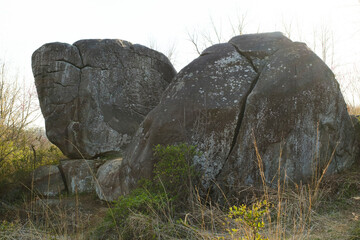 A unique elephant-shaped rock formation in Gettysburg, featuring large moss-covered boulders amidst dry grass and sparse trees under a clear sky