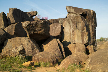 Massive rock formation in a natural landscape, showcasing rugged boulders under a clear sky. Perfect for themes of geology, nature, or outdoor adventure