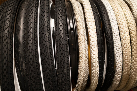 Rows of bicycle tires in black and beige, hanging neatly in a shop. Ideal for themes of cycling, repair, or vintage bike aesthetics
